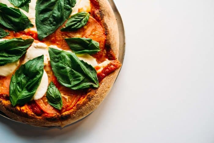 Soirée Pizza 1 pizza with green leaves on white ceramic plate