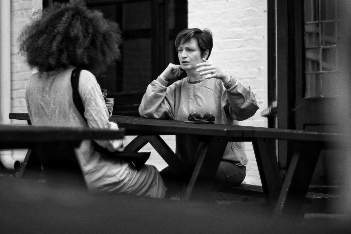 grayscale photo of two women sitting on bench